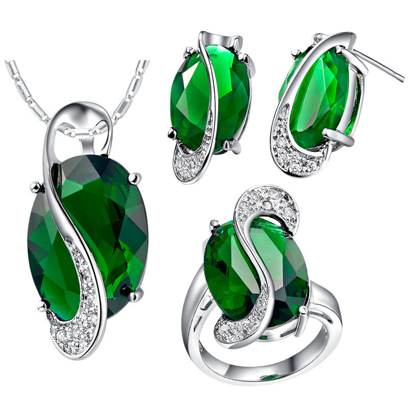 Jewelry set with green gemstones and silver accents on a white background