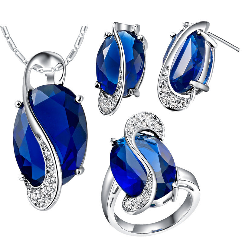 Jewelry set with blue gemstones and silver metal on a white background