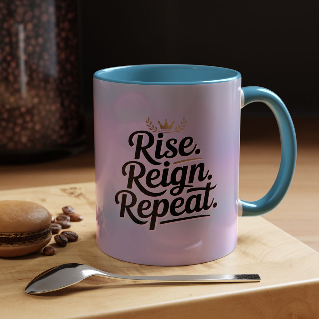 Mug with 'Rise. Reign. Repeat.' text on a wooden surface with coffee beans and a spoon.